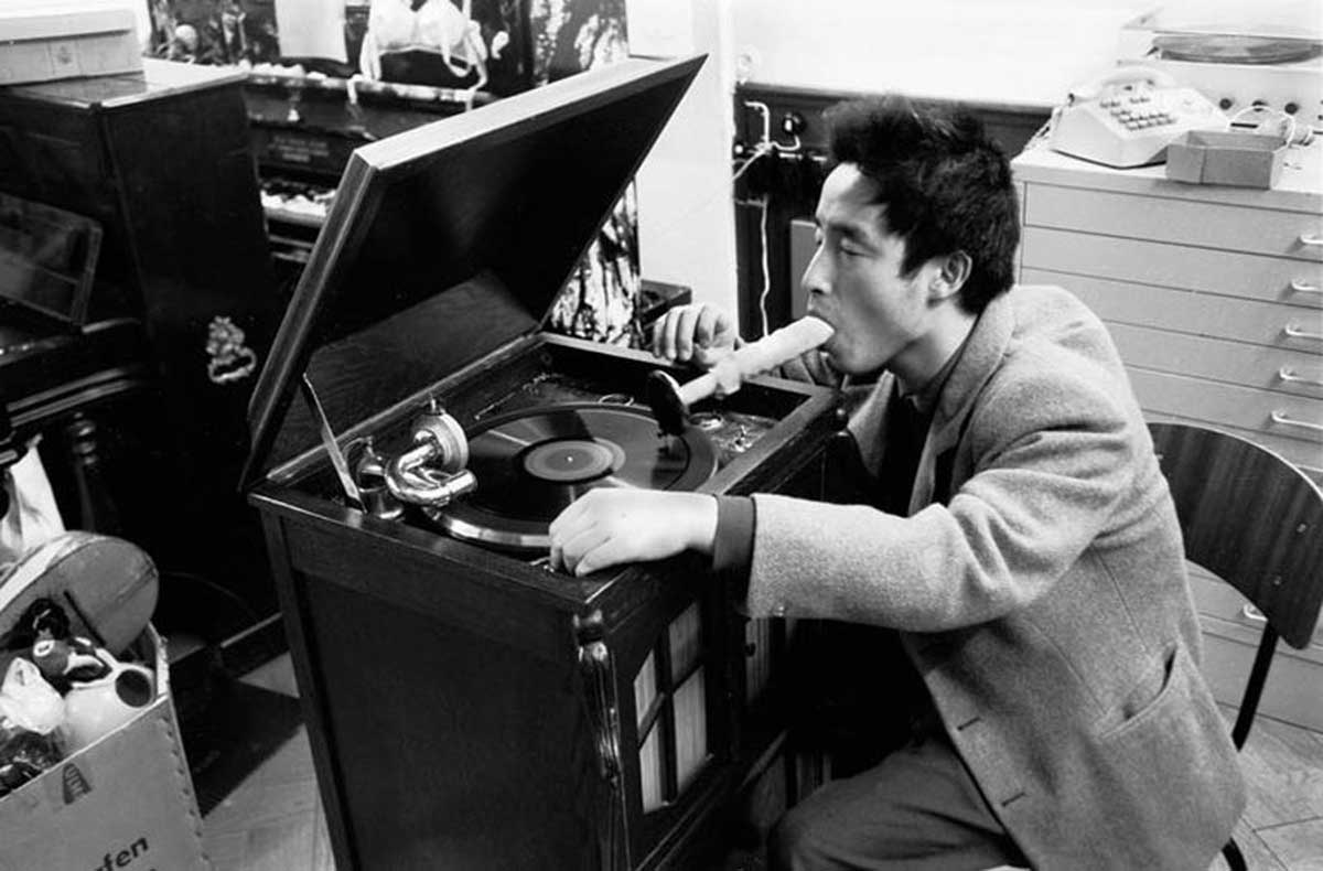 fig. 3: Nam June Paik demonstrates Listening to Music through the Mouth (1962–63) at Exposition of Music. Electronic Television,  Galerie Parnass, Wuppertal, Germany, March 1963. Collection of MuMOK, Vienna. Photo Manfred Montwé © montweART.